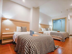 Habitación de hotel con dos camas, cabeceros de madera y un ventanal grande.