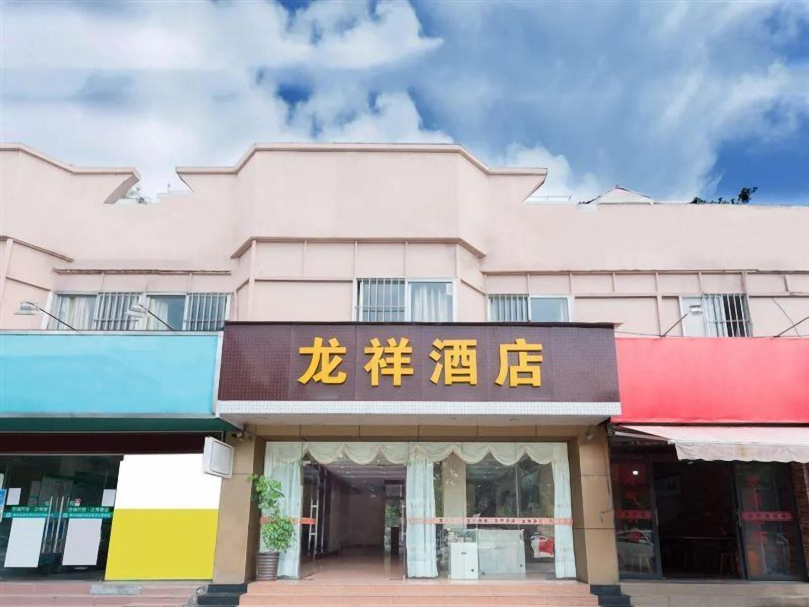 A hotel with a signboard, a storefront, and a clear sky.