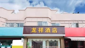 A hotel with a signboard, a storefront, and a clear sky.