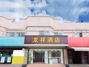 A hotel with a signboard, a storefront, and a clear sky. - Longxiang Hotel (Zhuhai)