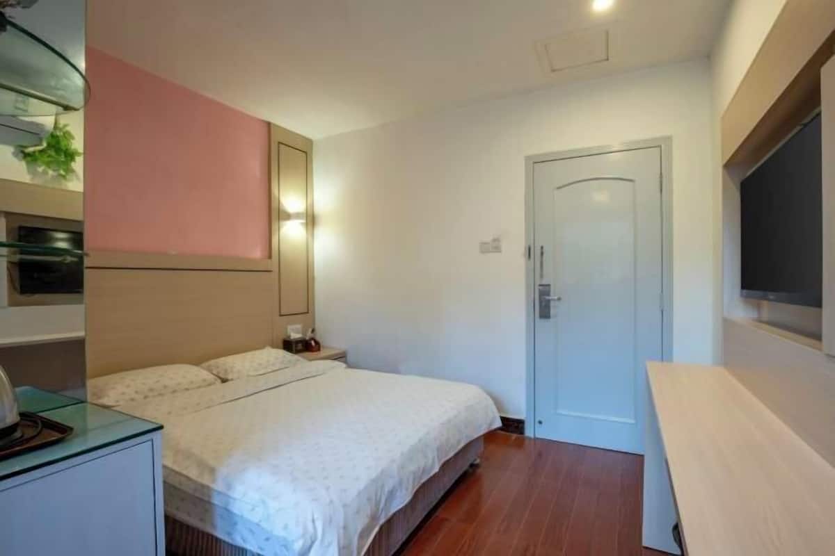 A bedroom with a bed, bedside table, and a door.
