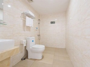 A bathroom with a toilet, a sink, and a shower. - Longxiang Hotel (Zhuhai)