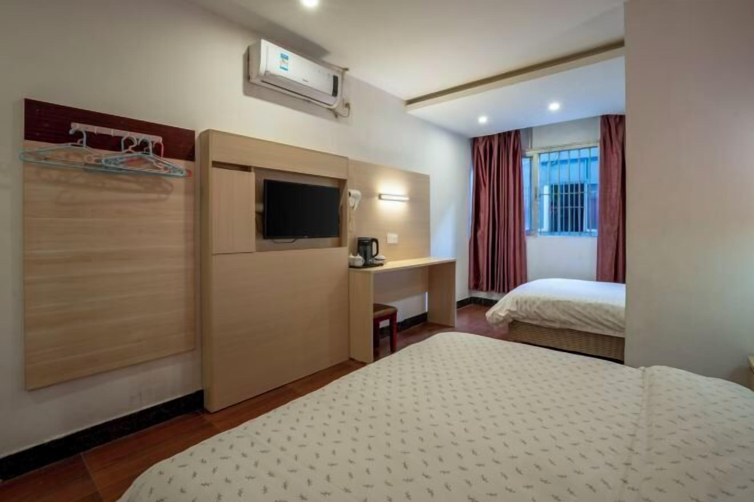 Una habitación de hotel con cama, televisión, escritorio y armario.