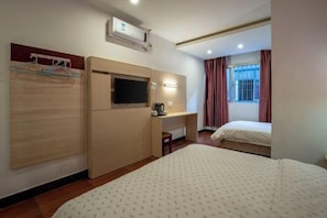 A hotel room with a bed, a TV, a desk, and a wardrobe. - Longxiang Hotel (Zhuhai)