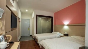 A hotel room with two beds, a TV, a coffee maker, and a wall-mounted light. - Longxiang Hotel (Zhuhai)