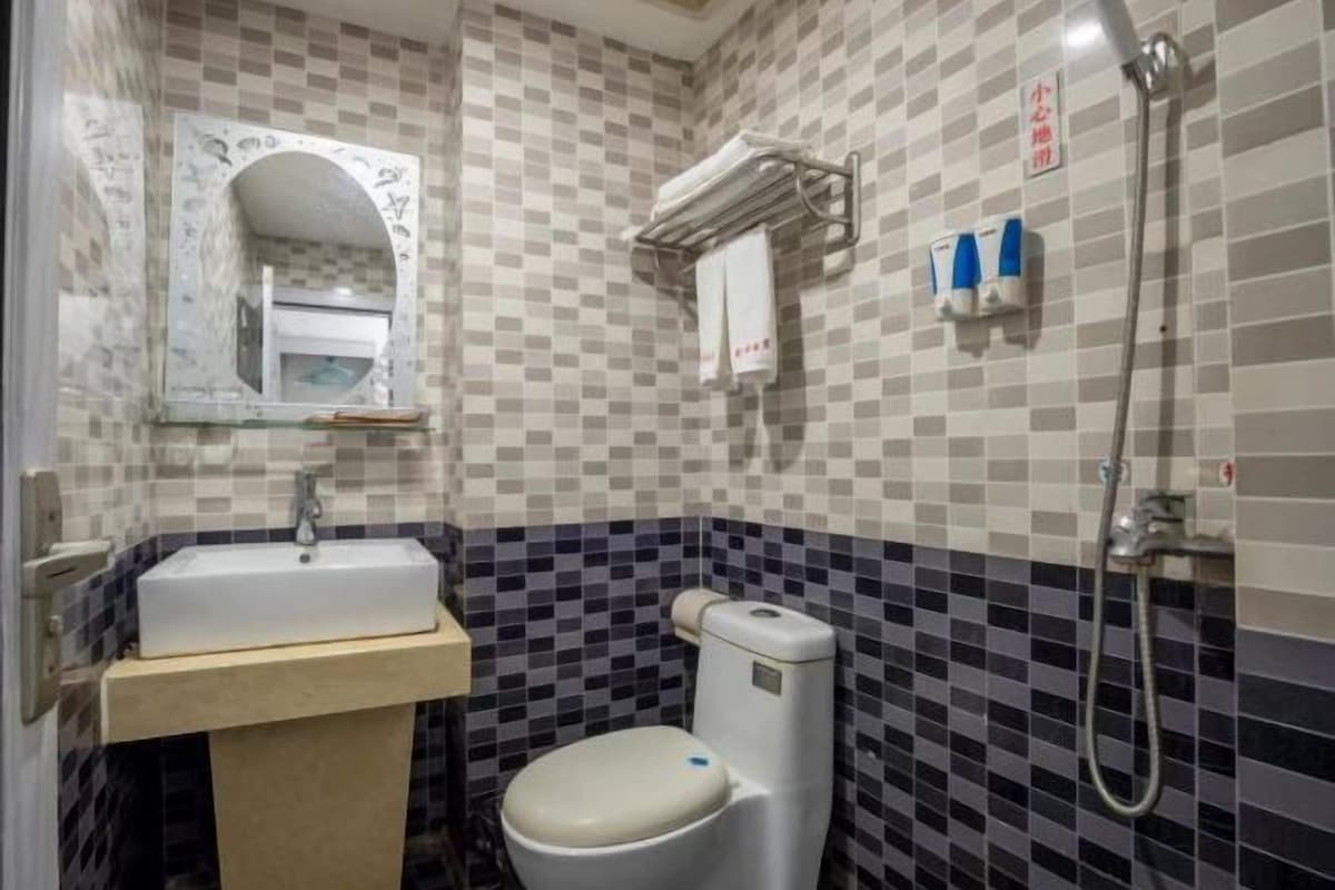 A bathroom with a sink, toilet, and shower.