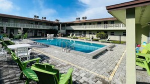 A pool area with lounge chairs and a pool. - Windward West 30 - Pool & 5 Minutes from the Beach (Cocoa Beach)