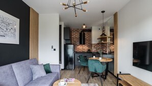 A modern living room with a grey sofa, a coffee table, and a TV mounted on the wall.