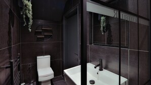 A modern bathroom with a toilet, sink, and a mirror. - Luxury Boutique 2 Bed Apartment in the heart of Bowness on Windermere (Bowness-on-Windermere)