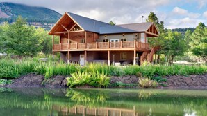 A log cabin with a balcony, a covered porch, and a view of a lake. - Bears Ears Luxury Retreat (Monticello)