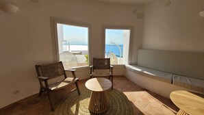 A balcony with two wicker chairs, a round wooden table, and a cushioned bench. - Agi Castell Mar 1001 Apartamento for rent in Roses Girona. (Roses)