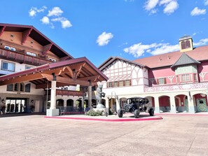 Ein Hotel mit überdachtem Außenbereich, einer Statue und einem roten Teppich, der zum Eingang führt.