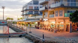 En strandpromenad med restauranger och butiker, där en välkänd restaurang som specialiserar sig på fiskrätter är ett av höjdpunkterna.