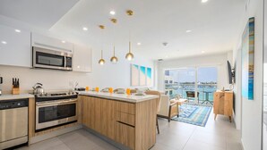 A modern kitchen with a central island, stainless steel appliances, and pendant lighting. - NEW Modern Oceanfront Luxury Complex in Aruba! (Oranjestad)