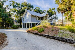 Stroll up the covered porch to the two-story house surrounded by lush trees and a well-manicured lawn.