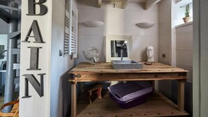 Un baño con tocador de madera, espejo y lavabo.