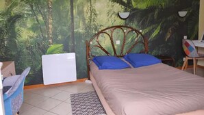 Een slaapkamer met een bed, een stoel, een bureau en een muurschildering van een bos.