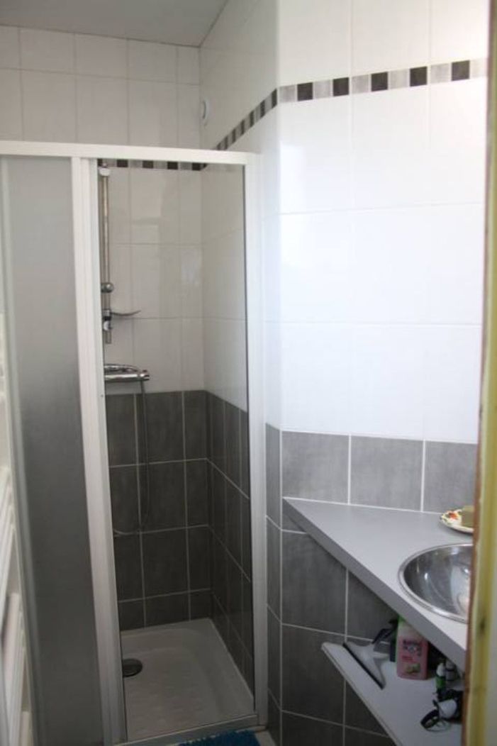 A bathroom with a shower, a toilet, and a sink.
