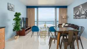 Una sala de estar moderna con un ventanal grande, un comedor y un área de descanso.