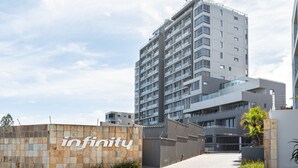 Un edificio moderno con un llamativo símbolo de infinito, que sugiere un hotel o complejo residencial.