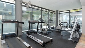 Un gimnasio moderno con cintas de correr, elípticas y equipo de pesas.
