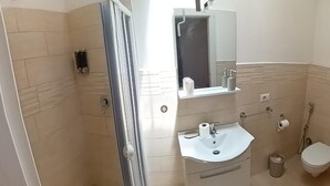 A bathroom with a shower, sink, and toilet. - La Fenice Budoni (Budoni)