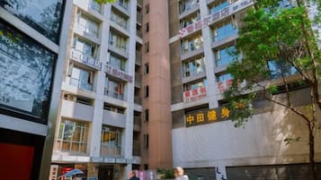 Un edificio de varios pisos con varios comercios en la planta baja, incluyendo un restaurante y una farmacia.