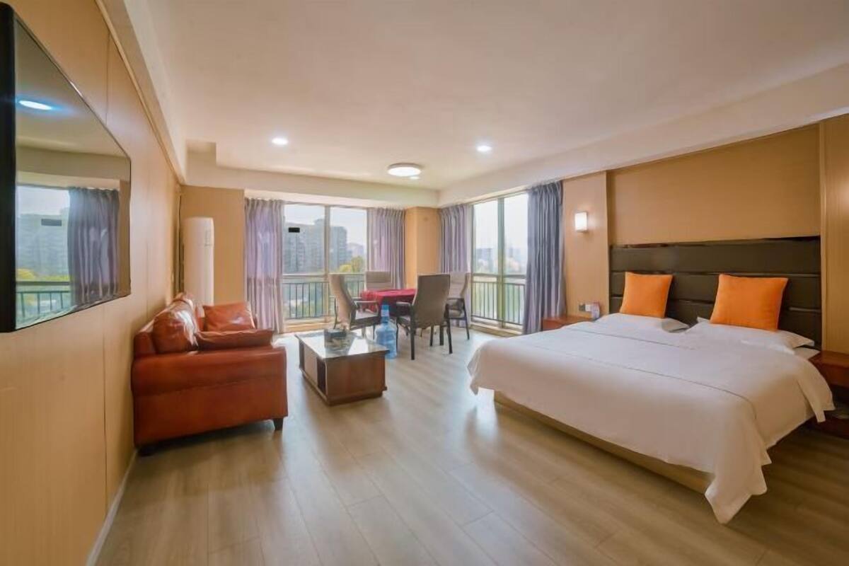 Una habitación de hotel con una cama grande, un sofá, un escritorio y una silla.