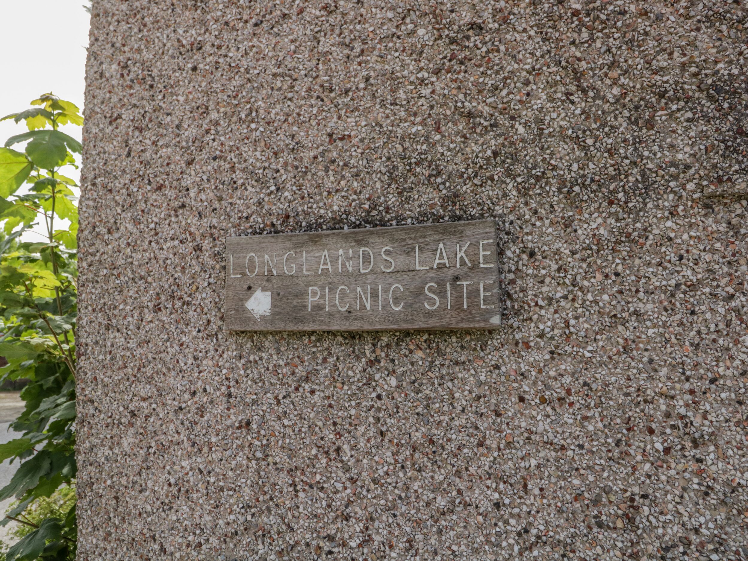 Señal en una pared de piedra que indica un área de picnic en Longlands Lake.
