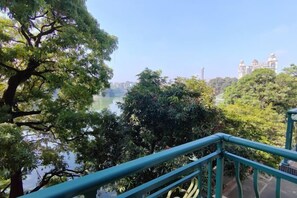 A view from a balcony with a railing, overlooking a body of water and trees. - Cuihu Hotel (Taishan)