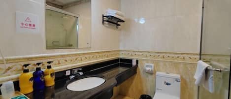Un baño con un lavamanos negro, un inodoro blanco y una cabina de ducha de vidrio.