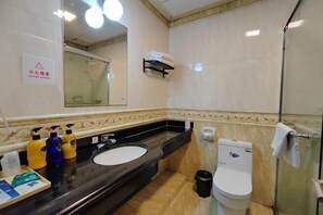 A bathroom with a black sink, a white toilet, and a glass shower enclosure. - Cuihu Hotel (Taishan)
