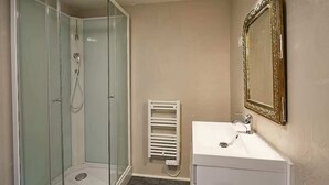 A bathroom with a glass-enclosed shower, a white sink, and a wall-mounted mirror. - Maisonnette 4 Personnes,  à 2 pas de la Mer, Ault (Ault)