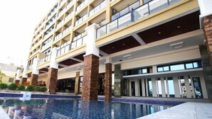 A modern hotel with a pool area, featuring a multi-story building with balconies and a clear view of the pool. - Xingyu Sea View Hotel (Sanya Nanbian, Hailu Huitou) (Sanya)