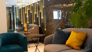 Una sala de estar moderna con sofá, sillón e lámparas colgantes.