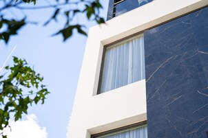 Un edificio moderno con fachada blanca y detalles en mármol oscuro.