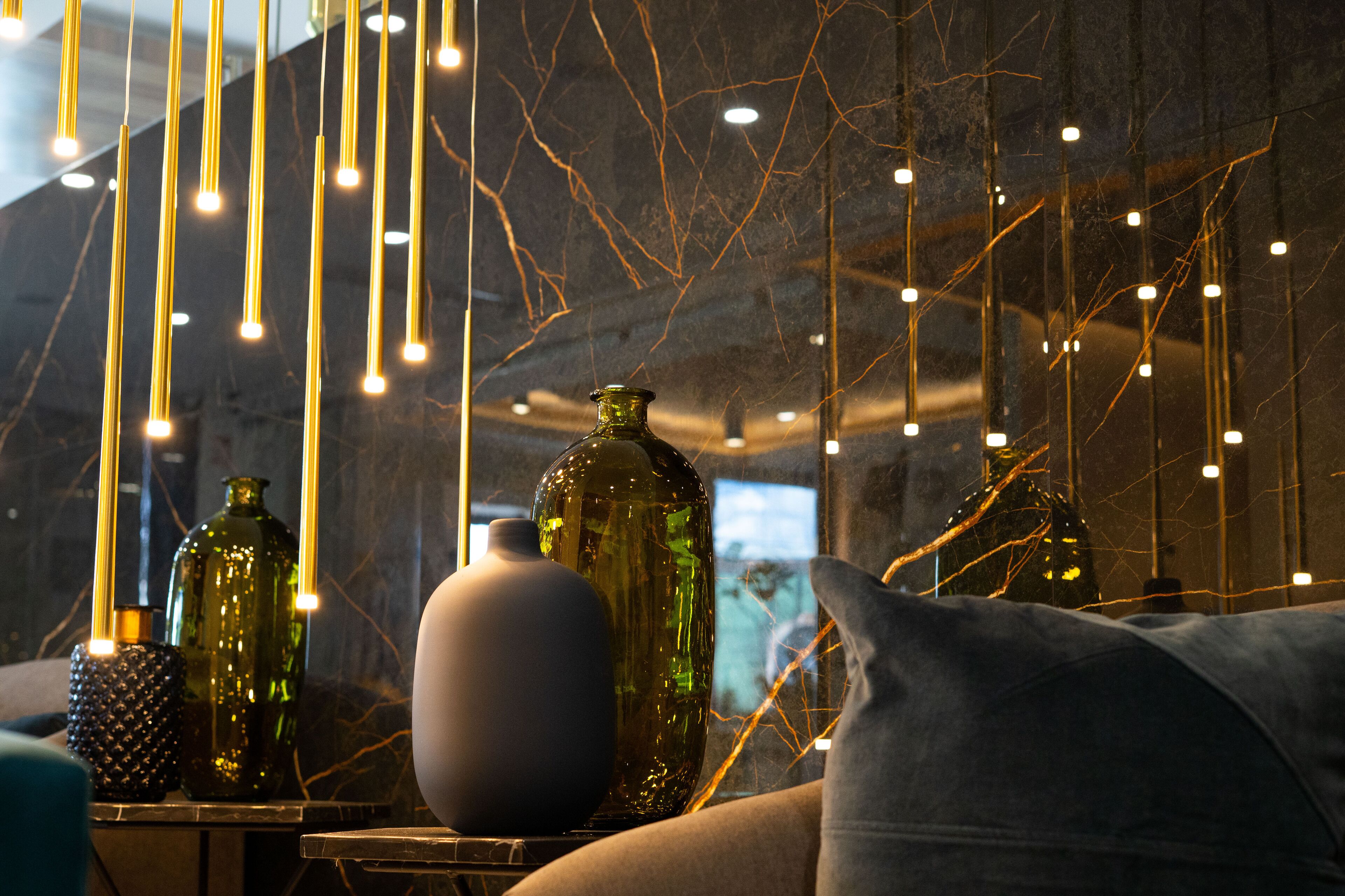 Ein Zimmer mit hängenden Lampen, einer Couch und dekorativen Vasen.
