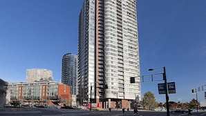 Un edificio residenziale alto con numerosi balconi e un design architettonico moderno.