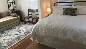 Une chambre avec un grand lit, un canapé, un fauteuil et une petite table.