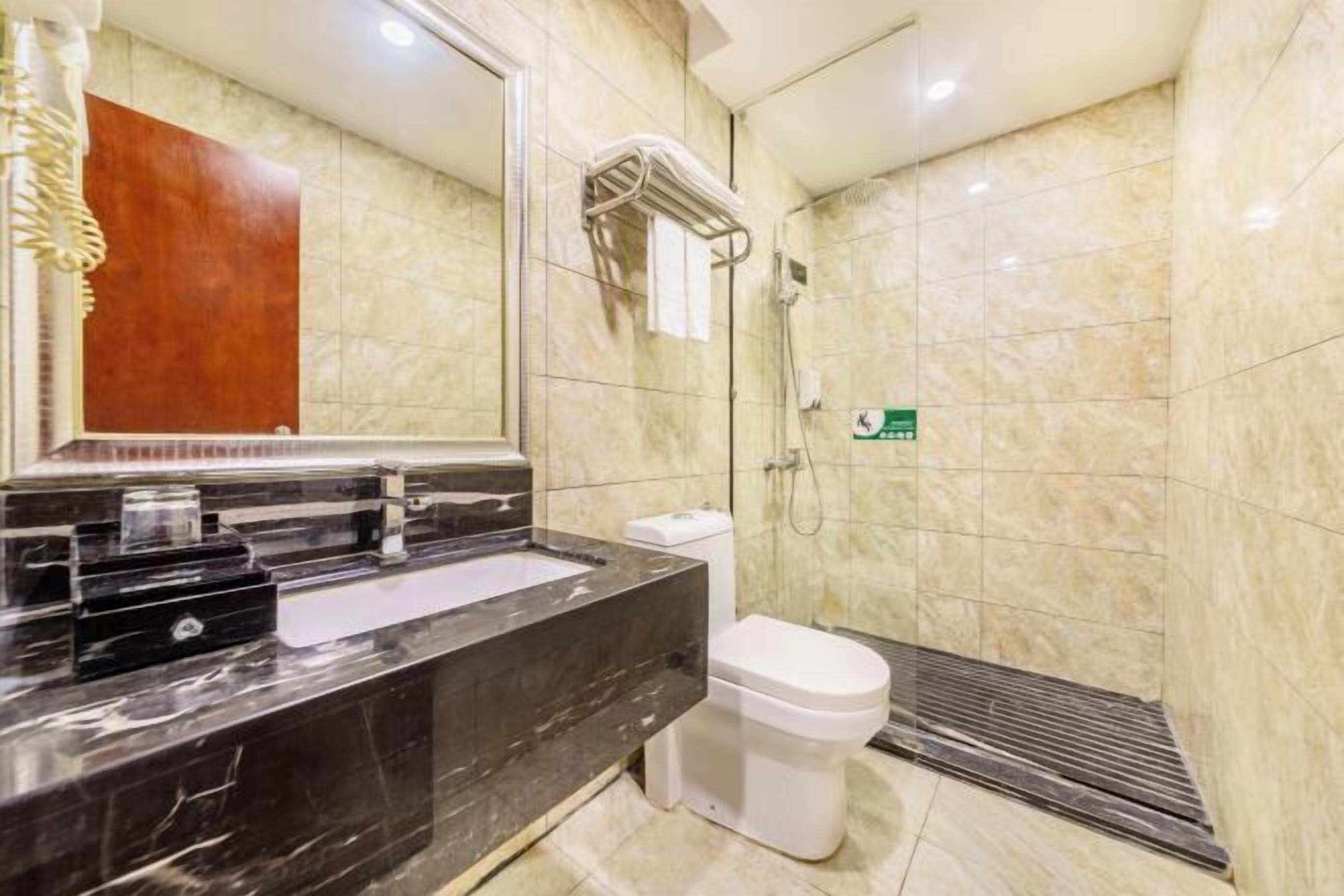 A modern bathroom with a marble sink, a white toilet, and a shower area.