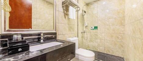 A modern bathroom with a marble sink, a white toilet, and a shower area.