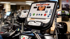 A treadmill with a digital display indicating a 'Select Workout'.