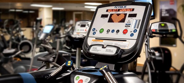Ein Laufband mit einem digitalen Display, das 'Training auswählen' anzeigt.