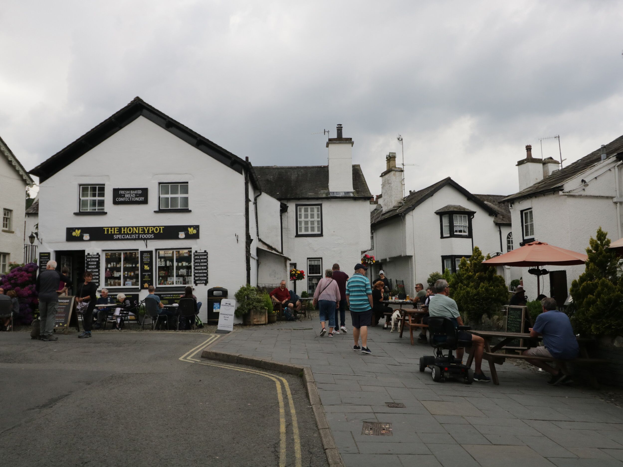 A town square with a white building labeled 'The Honeypot' offering specialist foods.