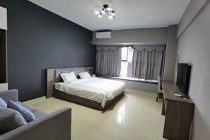 Une chambre d’hôtel moderne équipée d’un lit, d’un bureau, d’une chaise et d’un téléviseur.
