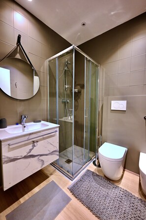 A modern bathroom with a glass-enclosed shower, a marble sink, and a toilet. - Juliet Suite by di.bi rooms (Verona)
