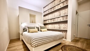 Ein Schlafzimmer mit einem großen Bett, einem Bücherregal und einer Tür.
