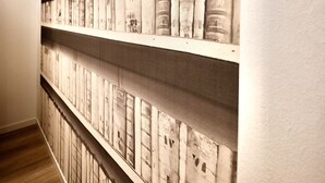 Eine Wand mit mehreren Regalen, auf denen Bücher stehen.