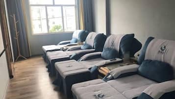 Comfortable beds with headboards and footboards, each with a logo, are arranged in a row.