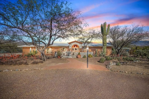 A desert-style building with a central patio, surrounded by cacti and desert plants.